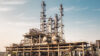Industrial chemical processing plant with tall distillation columns and storage vessels
