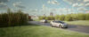 Electric passenger vehicle powered by a solid-state battery driving past wind turbines.