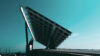 Large solar panel structure viewed from below against a clear blue sky.