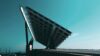 Large solar panel structure viewed from below against a clear blue sky.