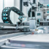 Automated manufacturing equipment operating on a high-precision production line, performing industrial processing and assembly tasks in a modern factory environment.