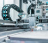 Automated manufacturing equipment operating on a high-precision production line, performing industrial processing and assembly tasks in a modern factory environment.