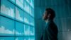Business professional analyzing data visualizations and performance metrics on a large digital dashboard, supporting data-driven decision-making and strategic planning.