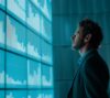 Business professional analyzing data visualizations and performance metrics on a large digital dashboard, supporting data-driven decision-making and strategic planning.