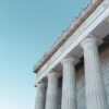 Classical building facade with large stone columns against a clear blue sky.