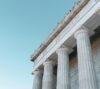 Classical building facade with large stone columns against a clear blue sky.