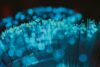 Abstract visualization of fiber optic technology with glowing blue and turquoise light signals.