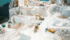 Terraced stone quarry with excavators and wheel loaders operating across multiple levels.
