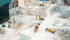 Terraced stone quarry with excavators and wheel loaders operating across multiple levels.